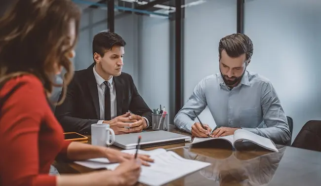 A divorcing couple is meeting with a family law attorney to discuss spousal maintenance laws and financial support obligations.